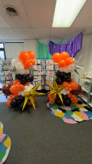 basketball themed custom free standing balloon garlands on bases in orange white and black with foil balloon accents